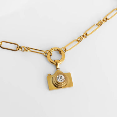 Gold necklace with a camera-shaped pendant on a white background