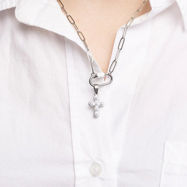Silver necklace with a cross pendant on a white shirt