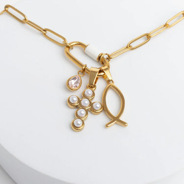 Gold necklace with fish and pearl charm on a white background