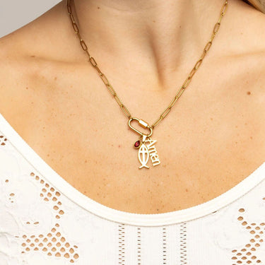 Gold necklace with a pendant on a person wearing a white top