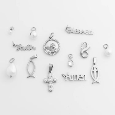 Collection of various silver pendants on a light gray background
