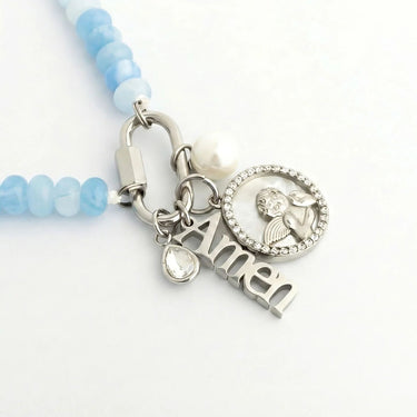Bracelet with blue beads and silver charms on a white background