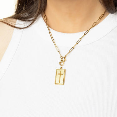 Gold chain necklace with a rectangular pendant worn by a person on a white background