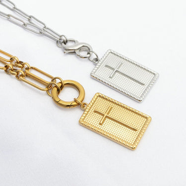 Two gold and silver necklaces with cross pendants on a white background