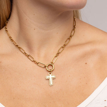 Gold chain necklace with a cross pendant on a person's neck