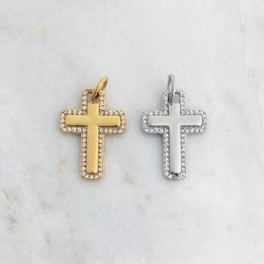 Gold and silver cross pendants on a marble surface