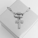 Silver necklace with a cross pendant on a white box