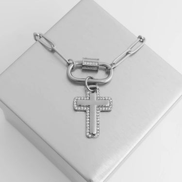 Silver necklace with a cross pendant on a white box