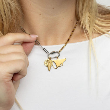 Gold necklace with unique pendant design worn by a person on a white background