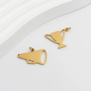 Gold megaphone and martini glass-shaped pendants on a white background