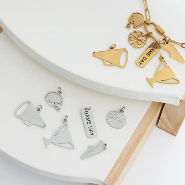 Gold and silver charms on a white surface