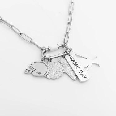 Silver necklace with various charms on a white background