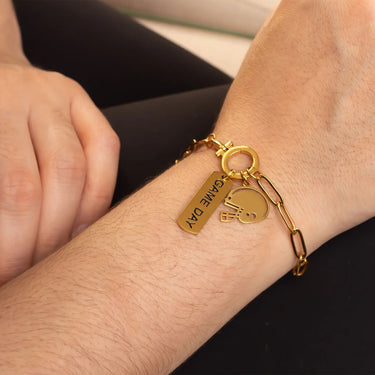 Gold bracelet with charms on a wrist