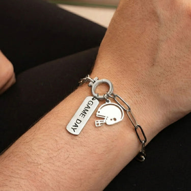 Silver bracelet with 'Some Day' tag and helmet charm on wrist