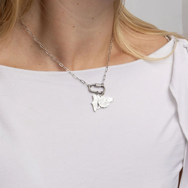 Silver necklace with a butterfly pendant worn by a person on a white background