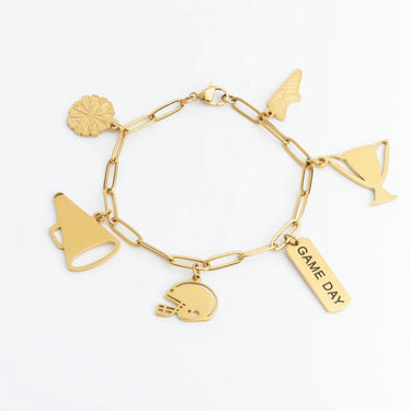 Gold charm bracelet with various charms on a white background