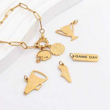 Gold charm bracelet with various charms on a white surface