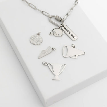 Silver necklace with various charms on a white background