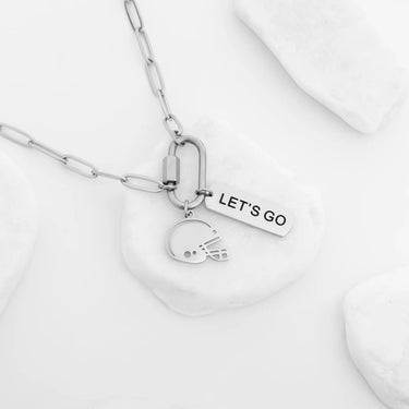 Silver necklace with helmet and 'LET'S GO' tag charm on a white background
