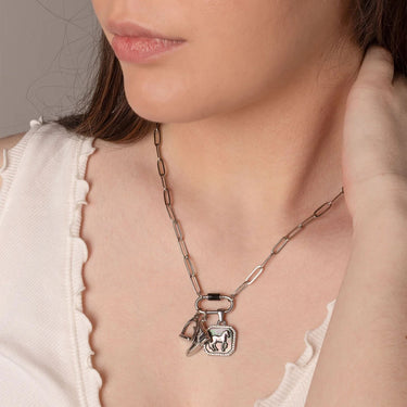 Close-up of a person wearing a necklace with a pendant.