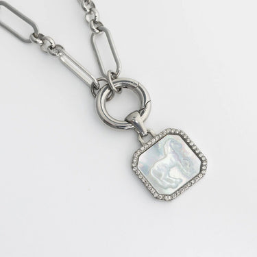 Silver necklace with a heart-shaped pendant on a light gray background