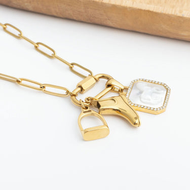 Gold necklace with horse bit and mirror charms on a white background