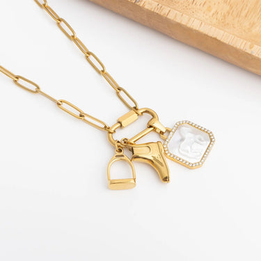 Gold necklace with horse bit and crystal pendant on a white background