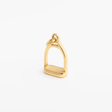 Gold stirrup charm on a white background