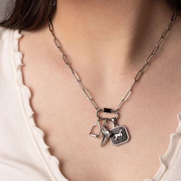 Silver necklace with horse-related charms worn by a person