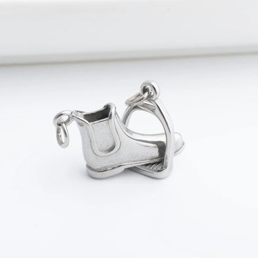 Silver boot and stirrup charm on a white background