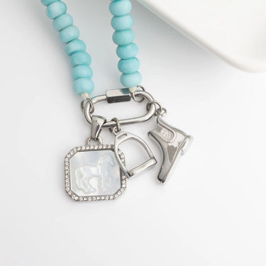 Necklace with turquoise beads and silver charms on a white background