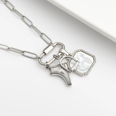 Silver necklace with horse, stirrup and boot charms on a white background