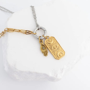Necklace with gold and silver charms on a white background