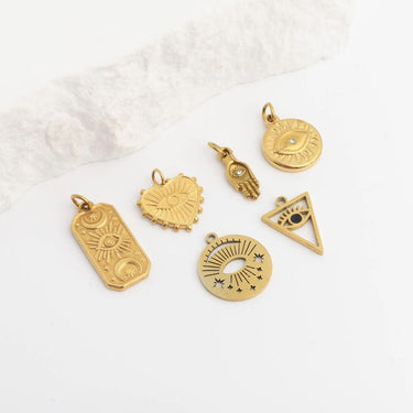 Collection of gold pendants on a textured white surface