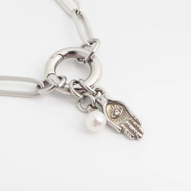 Silver bracelet with a charm featuring an eye design on a white background