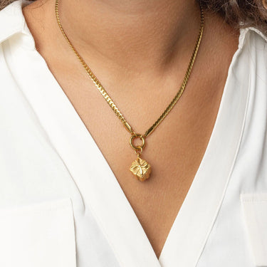 Gold necklace with a Present Charm on a person wearing a white shirt