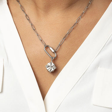 Silver necklace with a Present Charm on a person wearing a white top