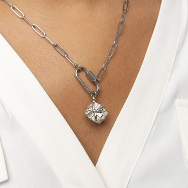 Silver chain necklace with a Present Charm on a person wearing a white top.