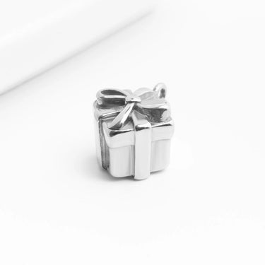 Silver gift box charm with a bow on a white background