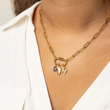 Gold necklace with Baby Foot Charm on a person wearing a white shirt