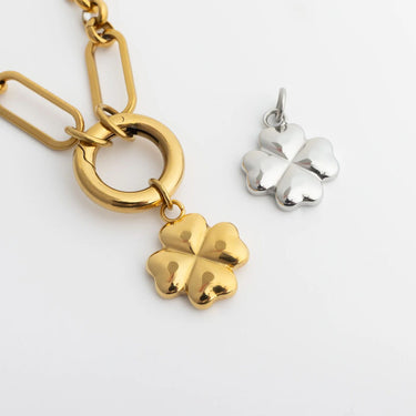 Gold and silver four-leaf clover charms on a white background