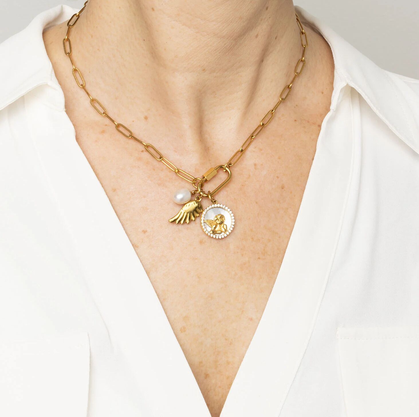 Gold necklace with charms on a white background