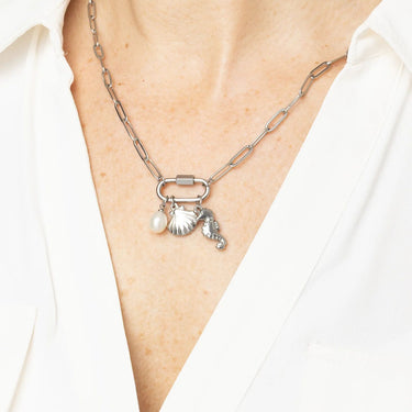 Necklace with charms on a person wearing a white shirt