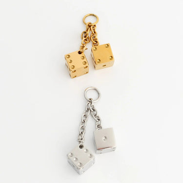 Gold and silver dice-shaped charms on a white background