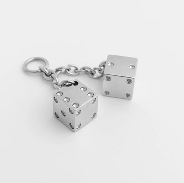 Silver dice charm on a white background