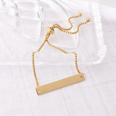 Gold necklace with a rectangular pendant on a white background