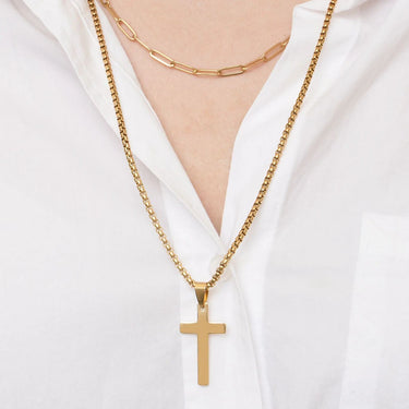 Gold necklace with a cross pendant on a white background