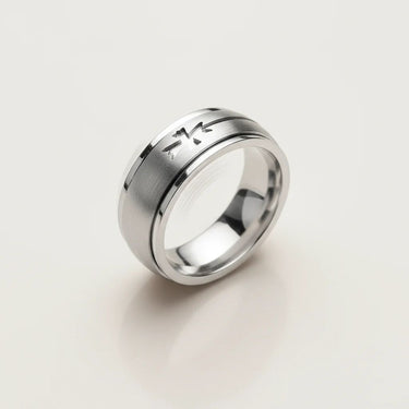 Silver ring with a textured design on a light gray background