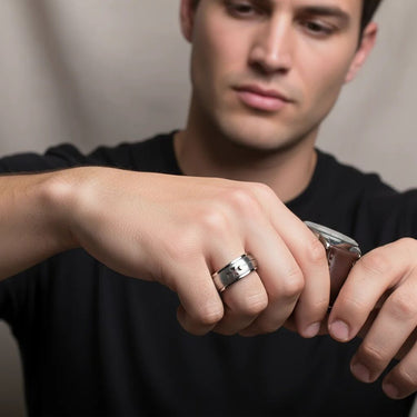 Man wearing a silver ring on his finger, holding a can.