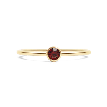 Gold ring with a red gemstone on a white background